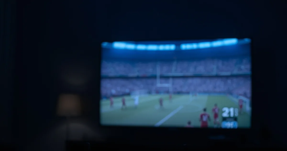 Un routeur Wi-Fi aux voyants allumés dans un salon plongé dans la pénombre, avec en arrière-plan un écran de télévision figé et pixelisé sur un match de football, illustrant le ralentissement réseau pendant les matchs.